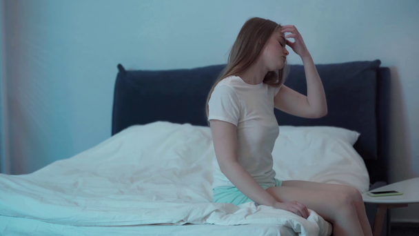 Mujer somnolienta sentada en la cama por la noche - Metraje, vídeo