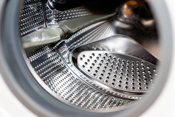 Modern kirli ya da temiz çamaşır makinesinin iç kapakları açık olan detaylarını kapatın. Gümüş renkli, paslanmaz davul, tasarım ve teknoloji. - Fotoğraf, Görsel