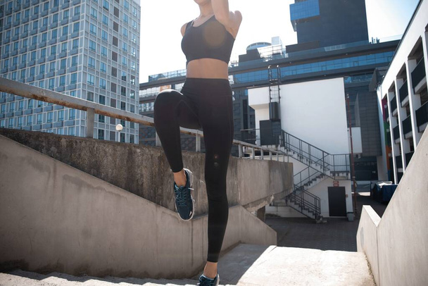 Slim brunette woman wears sports clothes jumping during her fitness workout. - Foto, immagini