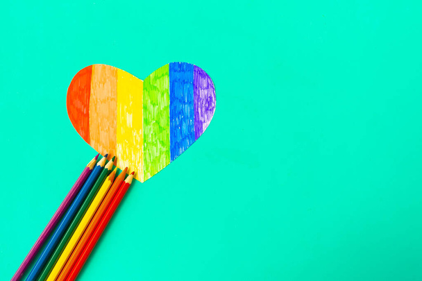 Καρδιά σε lgbtq χρώματα και μολύβια σε πράσινο φόντο μέντα, top view - Φωτογραφία, εικόνα