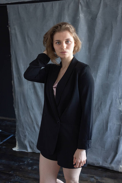 portrait of young caucasian woman with short hair posing in black suit jacket - Foto, imagen
