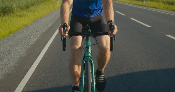 Zbliżenie rowerzysty ręce na kierownicy. Wciska hamulec i pedałuje. Trening na rowerze. 4K - Materiał filmowy, wideo