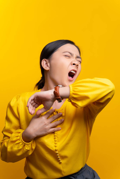 Mujer asiática estaba enferma de dolor de garganta, tos estornudos aislados sobre fondo amarillo. - Foto, imagen