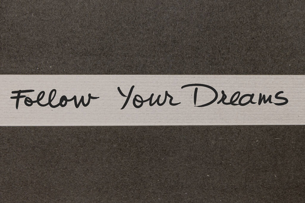 Białe i szare kolorowe tło papieru z Follow Your Dreams motywacyjny odręcznie napisane wiadomość - Zdjęcie, obraz