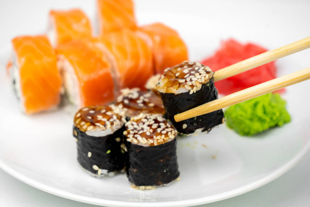philXoa maki rouleaux et anguille unagi maki avec sauce soja, gingembre rose, wasabi sur fond blanc, nourriture asiatique, ensemble de sushis japonais - Photo, image