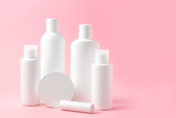 Set of white cosmetic bottles and jars on pink background with place to add text - Foto, immagini