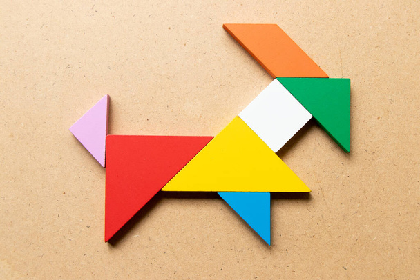 Color tangram puzzle in goat shape on wood background - 写真・画像