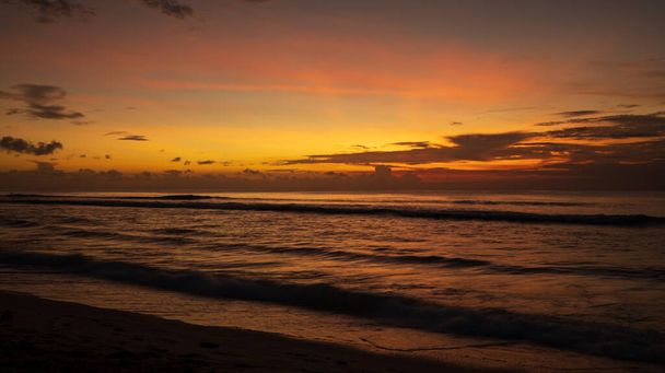 Plage au coucher du soleil. Paysage marin. Lumière du soleil brillante. Soleil à la ligne d'horizon. Vue panoramique. Coucher de soleil heure dorée. Réflexion de la lumière dans l'eau. Magnifique paysage. Plage de Balangan, Bali, Indonésie  - Photo, image