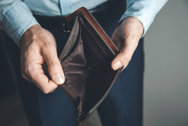 Man hand empty wallet on dark background - Фото, изображение