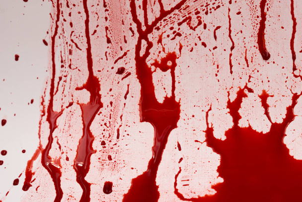 Beyaz arka planda kanlı sıçramalar ve damlalar. Damlayan ve takip eden kırmızı kan (boya) - Fotoğraf, Görsel