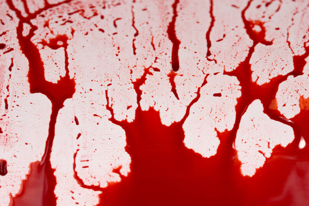 Bloody splashes and drops on a white background. Dripping and following red blood (paint) - Foto, Imagen