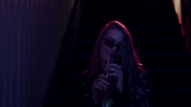 mujer en gafas de sol bebiendo cóctel y tocando el cabello - Imágenes, Vídeo