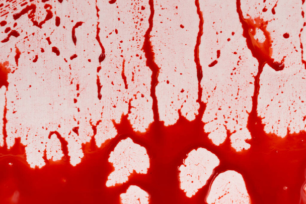 Bloody splashes and drops on a white background. Dripping and following red blood (paint) - Fotografie, Obrázek
