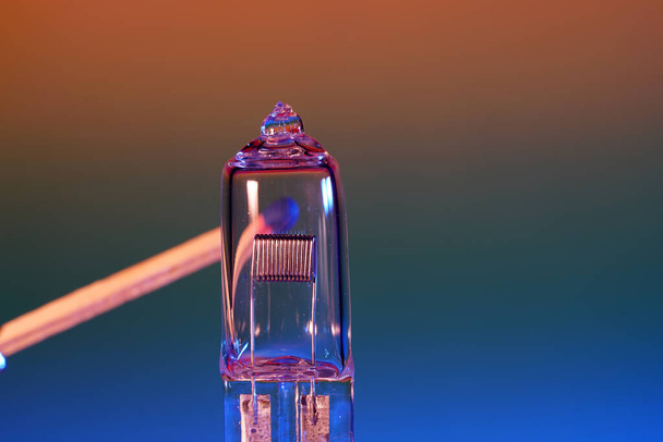 A closeup shot of an electric light bulb and a match - Photo, image