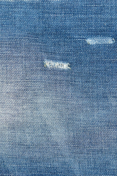 Ripped blue jeans met een gat textuur achtergrond - Foto, afbeelding