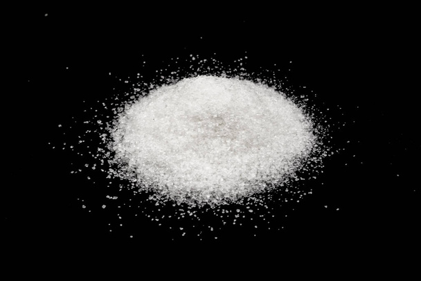 Scattered sugar on a black background - Фото, изображение