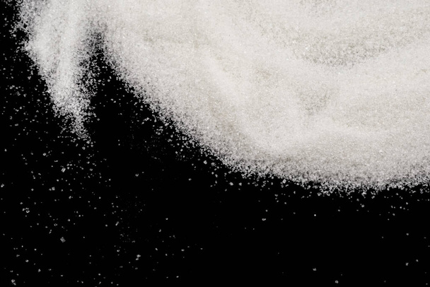 Scattered sugar on a black background - Fotografie, Obrázek