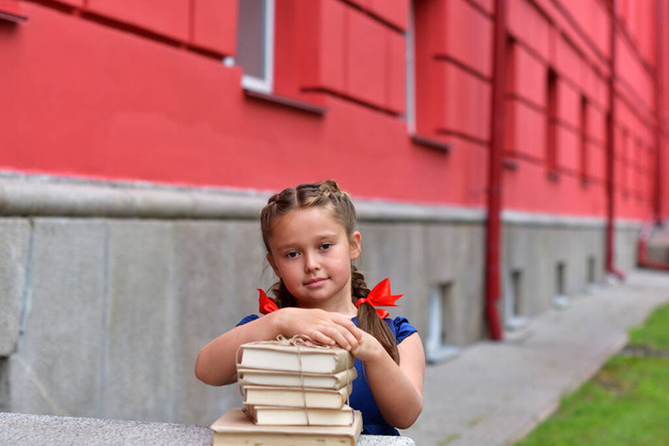 Portrait of beautiful young school girl with books on school background. day of knowledge. beginning of the school year. day of knowledge. beginning of the school year.Selective Focus - Photo, Image
