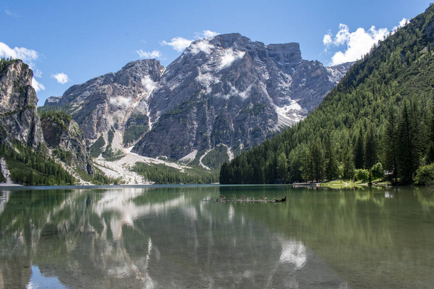 Zicht op het meer Braies, Pragser Wildsee is een meer in de Prags Dolomieten, Zuid-Tirol, Italië. Schaduw van de bomen, spiegel van ongerept water, rotsen, mineralen en bergen. Covidenvrije bestemmingen - Foto, afbeelding