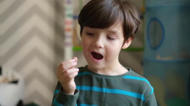 Un piccolo bel ragazzo mostra che i suoi denti da latte sono caduti. Il concetto di cambiare i denti nei bambini - Filmati, video