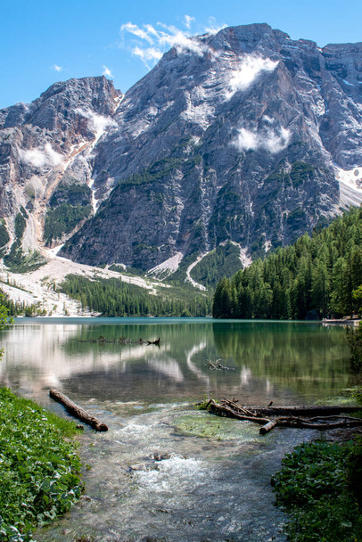 Vista sul lago di Braies, Pragser Wildsee è un lago delle Dolomiti di Prags, Alto Adige, Italia. Ombra degli alberi, specchio di acqua incontaminata, rocce, minerali e montagne. Destinazioni libere Covid - Foto, immagini