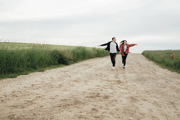 Młoda piękna para spacery na świeżym powietrzu w polu - Zdjęcie, obraz