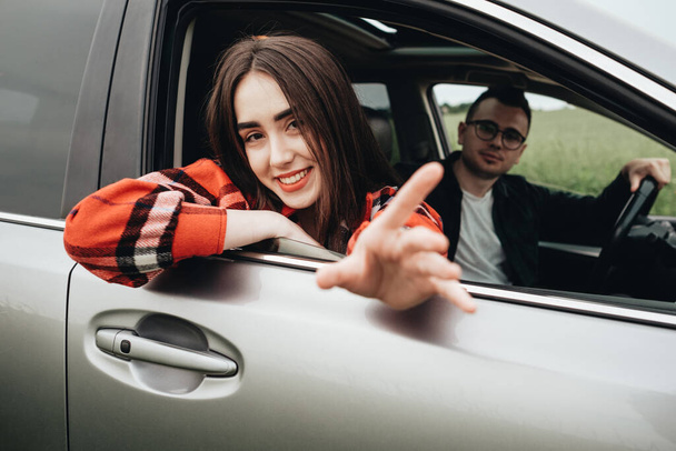 Young Beautiful Couple Sitting in Car and Enjoying the Roadtrip - Photo, image