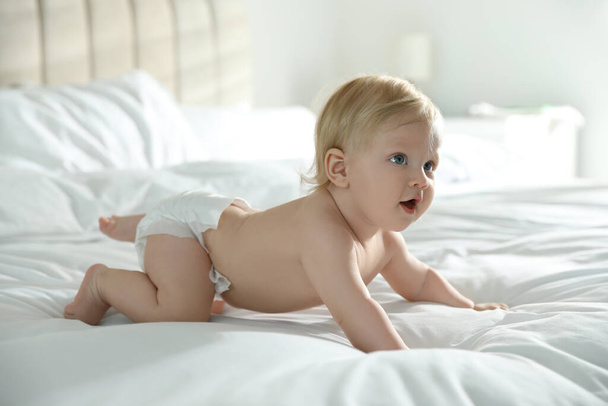 Cute little baby in diaper on bed at home - Zdjęcie, obraz
