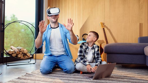 Happy young father and son testing virtual reality glasses playing augmented video reality games. - 写真・画像