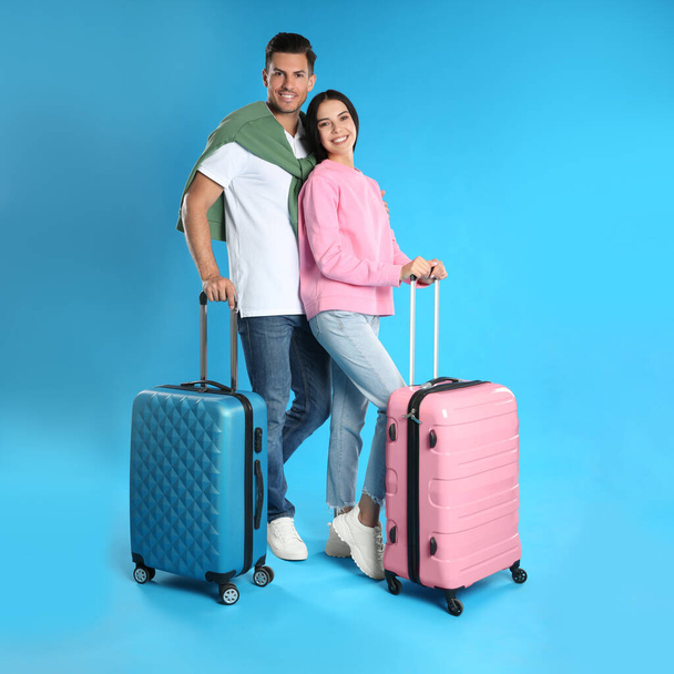 Happy couple with suitcases for summer trip on blue background. Vacation travel - Photo, Image