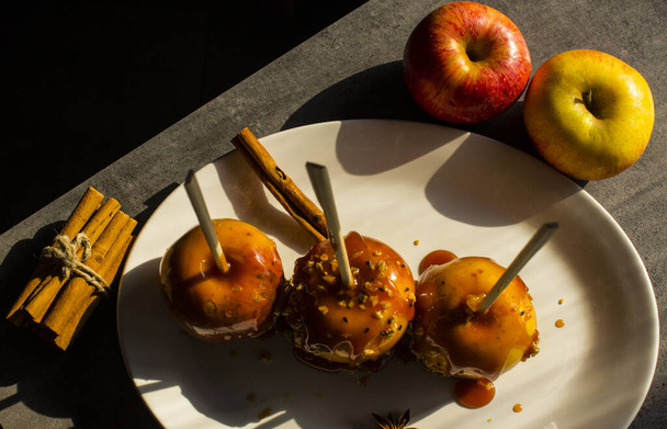 Pommes au caramel sur bâtonnets. Dessert festif photo rapprochée. Gâteries sucrées pour Halloween. - Photo, image