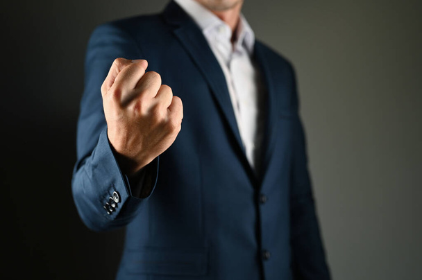 A man in a suit threatens with his fist. High quality photo - Foto, imagen