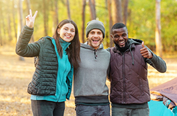 Mladí cool turisté pózují nad táborem v lese - Fotografie, Obrázek