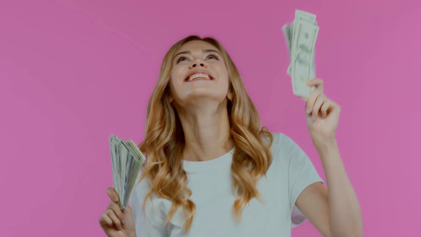 Aufgeregte blonde Frau tanzt mit Dollars auf Lila - Filmmaterial, Video