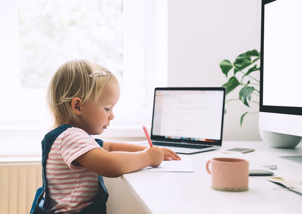 Little girl studying and drawing at desk. Preschool child using computer in early development or entertainment at home. Children homeschooling and distance online education. Kids online learning. - Φωτογραφία, εικόνα