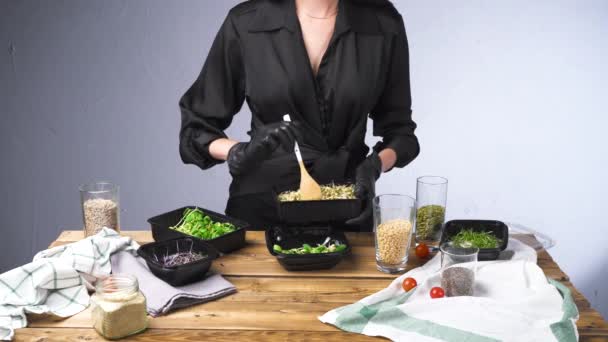 Images de femme en robe noire cuisine salade avec micro vert et graines - Séquence, vidéo