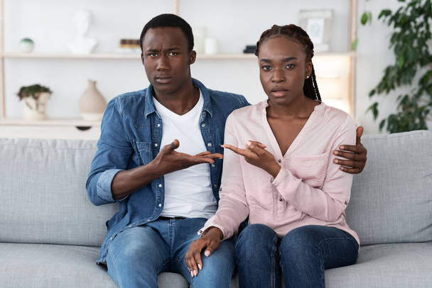 関係の誤解だ。家族カウンセラーオフィスでソファに座っている混乱した黒人夫婦 - 写真・画像