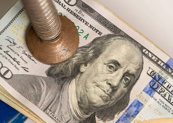 Etats-Unis cent dollars billets étant coincés entre les mâchoires solides d'un étau ou vice - Photo, image