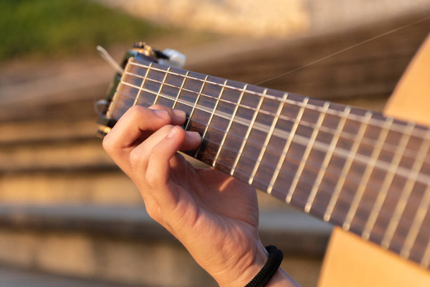 κοντινό χέρι γυναίκα παίζει κιθάρα - Φωτογραφία, εικόνα