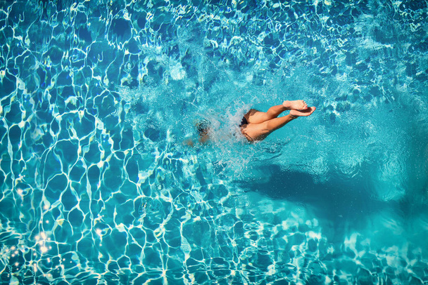 woman diving  at luxury five stars  spa resort in the swimming pool in Greece - Φωτογραφία, εικόνα