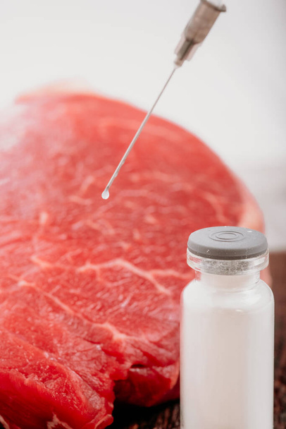Injektion von Wachstumshormonen und Chemikalien in rohes Rindfleisch. Biologische Experimente mit Antibiotika in der Nahrungsmittelproduktion. - Foto, Bild