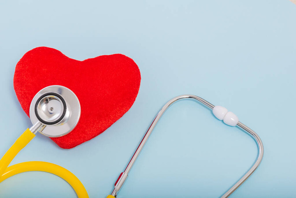Red heart, Yellow Stethoscope on blue background with Copy space. Medical concept, Health care concept. - 写真・画像