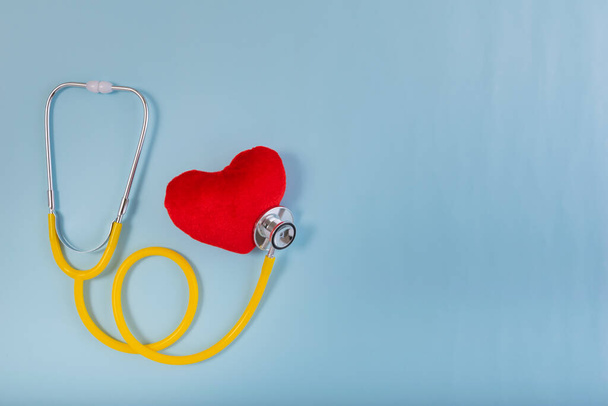 Red heart, Yellow Stethoscope on blue background with Copy space. Medical concept, Health care concept. - Foto, Imagen