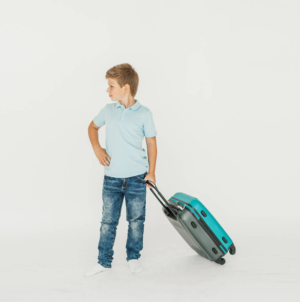 The young traveler boy with a suitcase. Isolated over white background - Zdjęcie, obraz