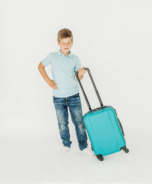 The young traveler boy with a suitcase. Isolated over white background - Foto, imagen