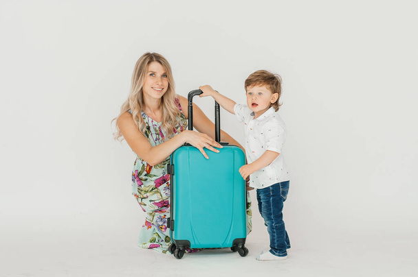 Travelling with kids. Happy mother with her child packing clothes for their holiday. Summer, vacation. - Фото, изображение
