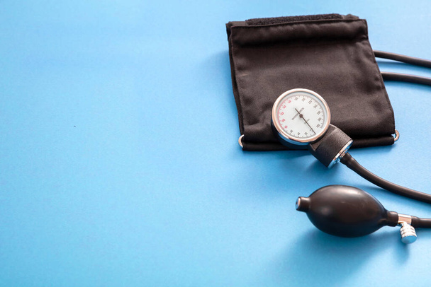 Hypertension control, Blood pressure measure, Medical sphygmomanometer on blue color background, closeup view, copy space. Health cardio checkup concept. - Photo, Image