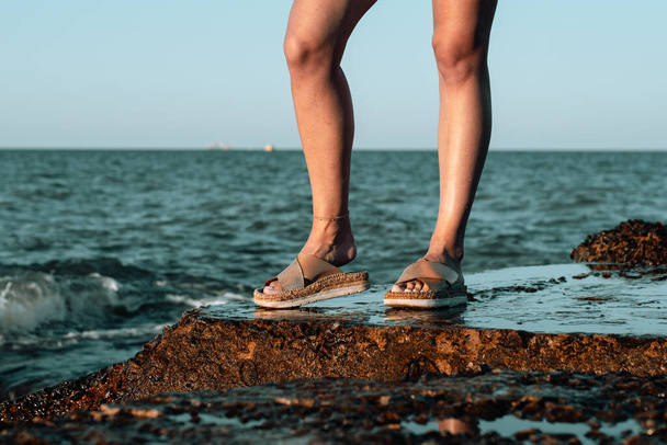 Lány láb, gyalogút a strandon lány kinyújtja a kezét, a tenger mellett - Fotó, kép