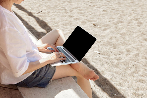 Mladá žena používající notebook na pláži. Koncept práce na volné noze - Fotografie, Obrázek