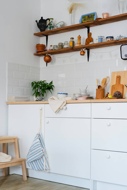 white kitchen interior. Scandinavian interior design in light colors with plants and accessories. Sunny day - Foto, Imagem